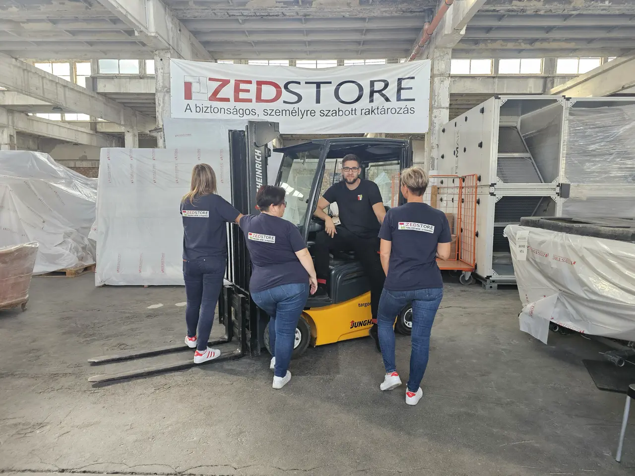 The ZedStore team working together in the warehouse around a forklift